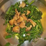 Broccolini and oyster mushrooms in stainless steel pan